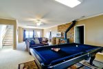 Basment Level Living Room Features a Wood Burning Fireplace, 40 4K Smart TV, Ample Seating, Pool Table, and Air Hockey